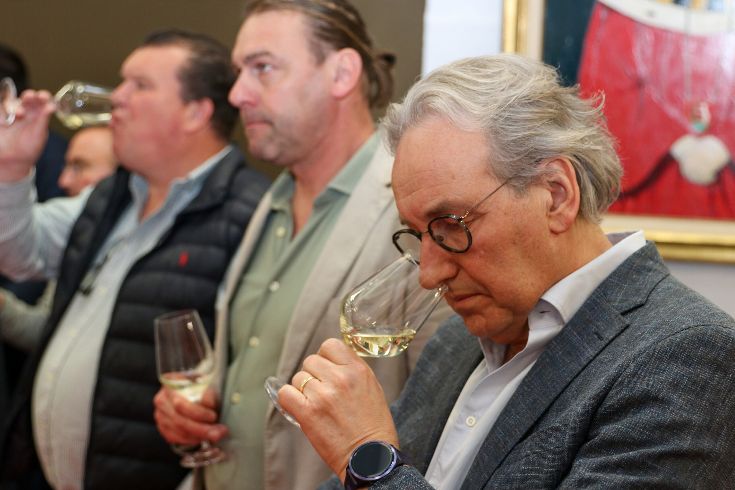 Ondernemer proeft de wijn, snuift de geur in het glas.