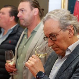 Ondernemer proeft de wijn, snuift de geur in het glas.